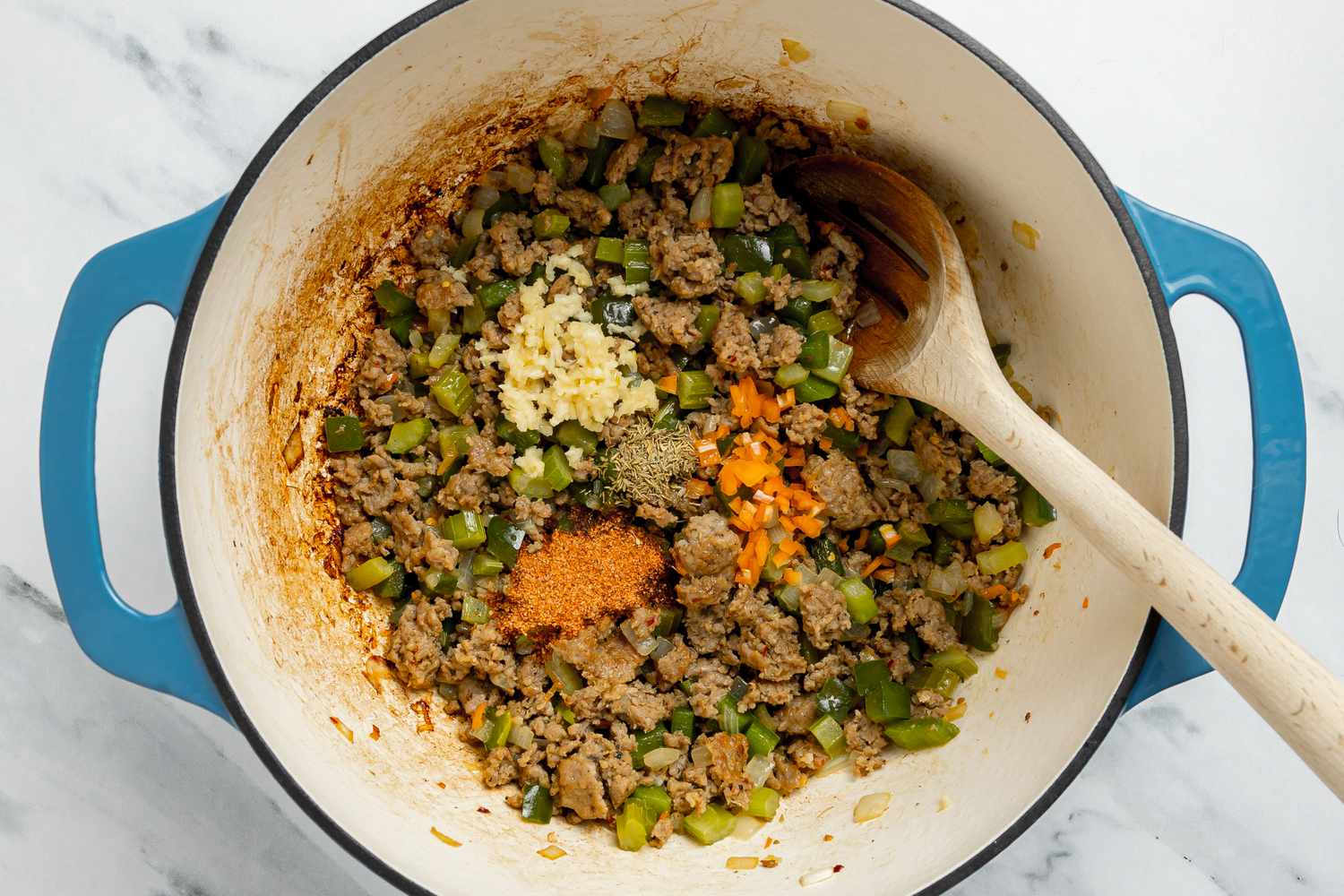 Garlic and Spices Added to Creole Dirty Rice With Shrimp Ingredients in Dutch Oven
