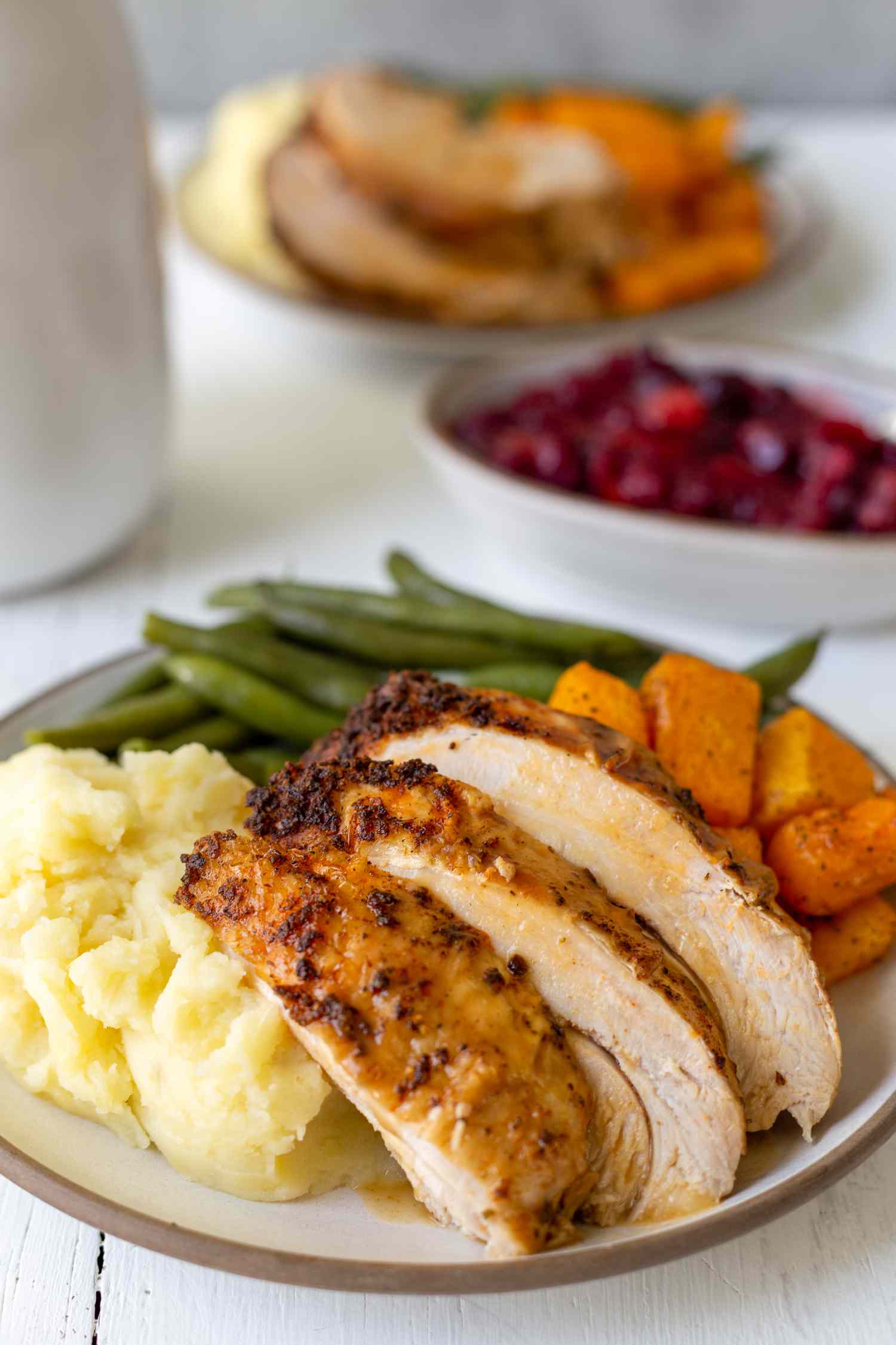 Simple instant pot turkey with gravy sliced and served on a plate with mashed potatoes and green beans.