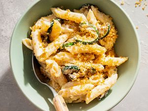 A bowl of penne pasta with ricotta cheese zucchini and breadcrumbs