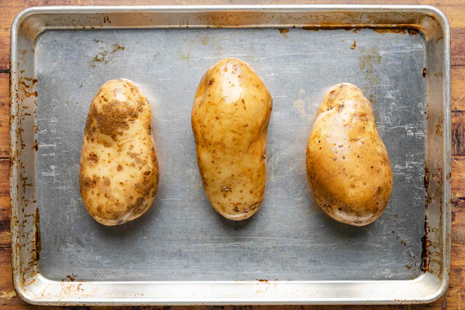 olive oil coated potatoes on a baking sheet for cheeseburger stuffed baked potatoes recipe
