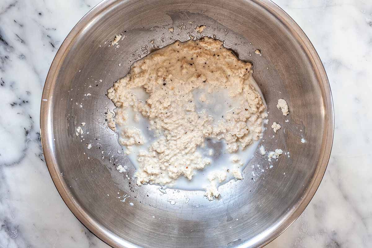 Ground beef and pork sausage meatball recipe - silver bowl with bread and milk mixture