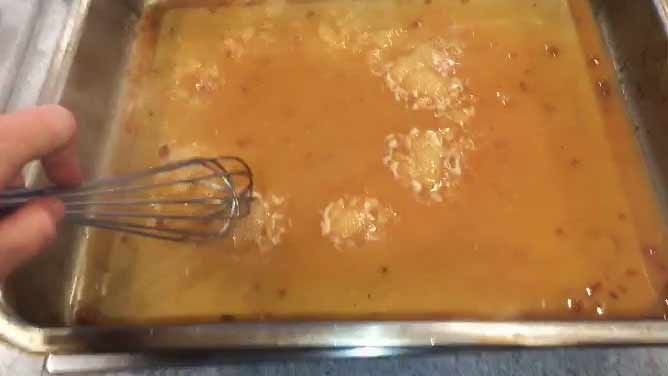 Flour and drippings being whisked together in a baking dish