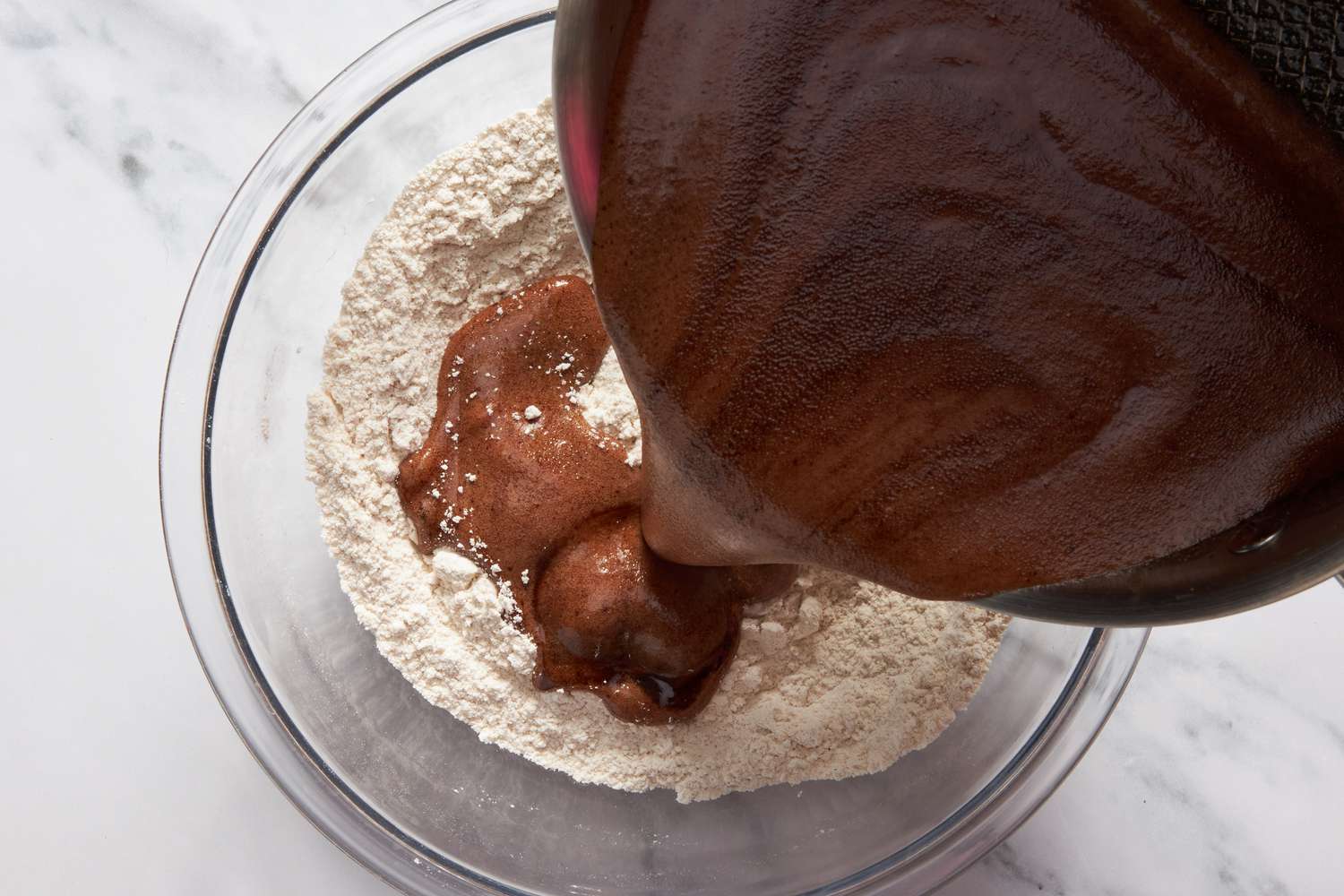 Dr. Pepper mixture poured into the bowl with dry ingredients for Dr. Pepper cake recipe