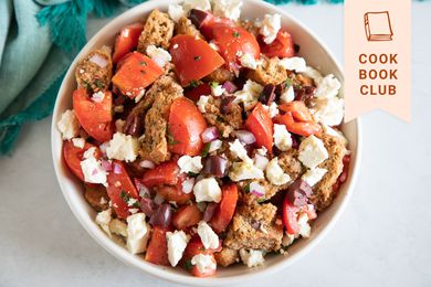 Overhead view of a white bowl filled with Cretan Dakos salad.