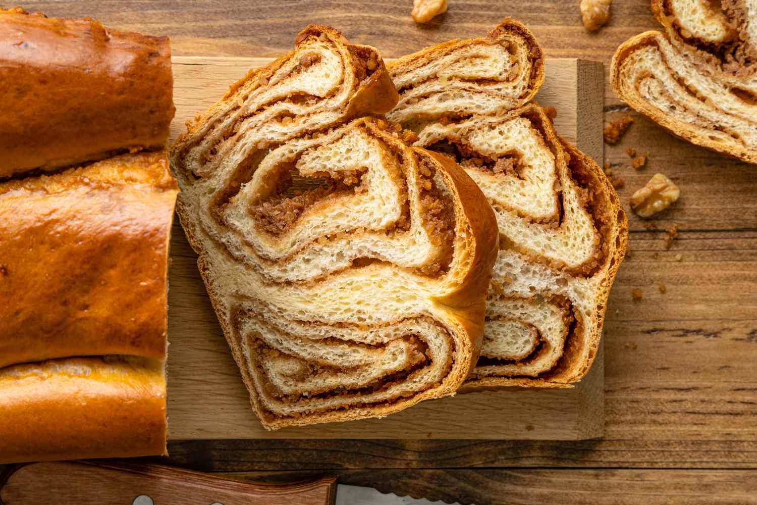 Slices of Povitica Next to a Loaf on a Cutting Board