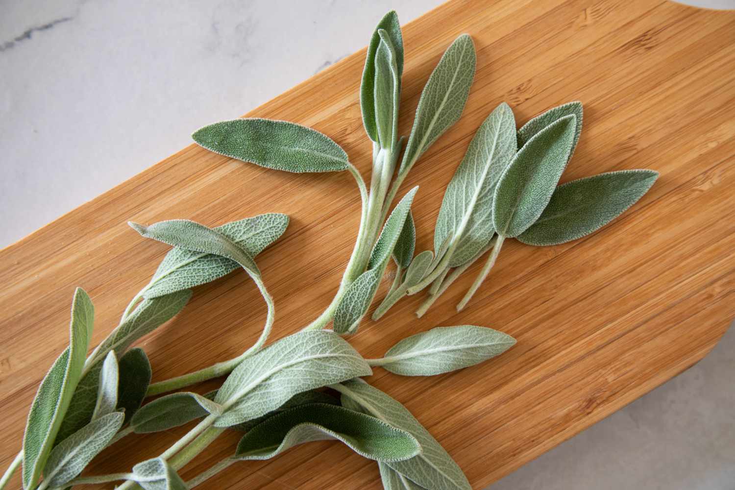 Whole sage on a wood cutting board