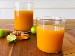 A glass and pitcher filled with Turmeric and Ginger Elixir.