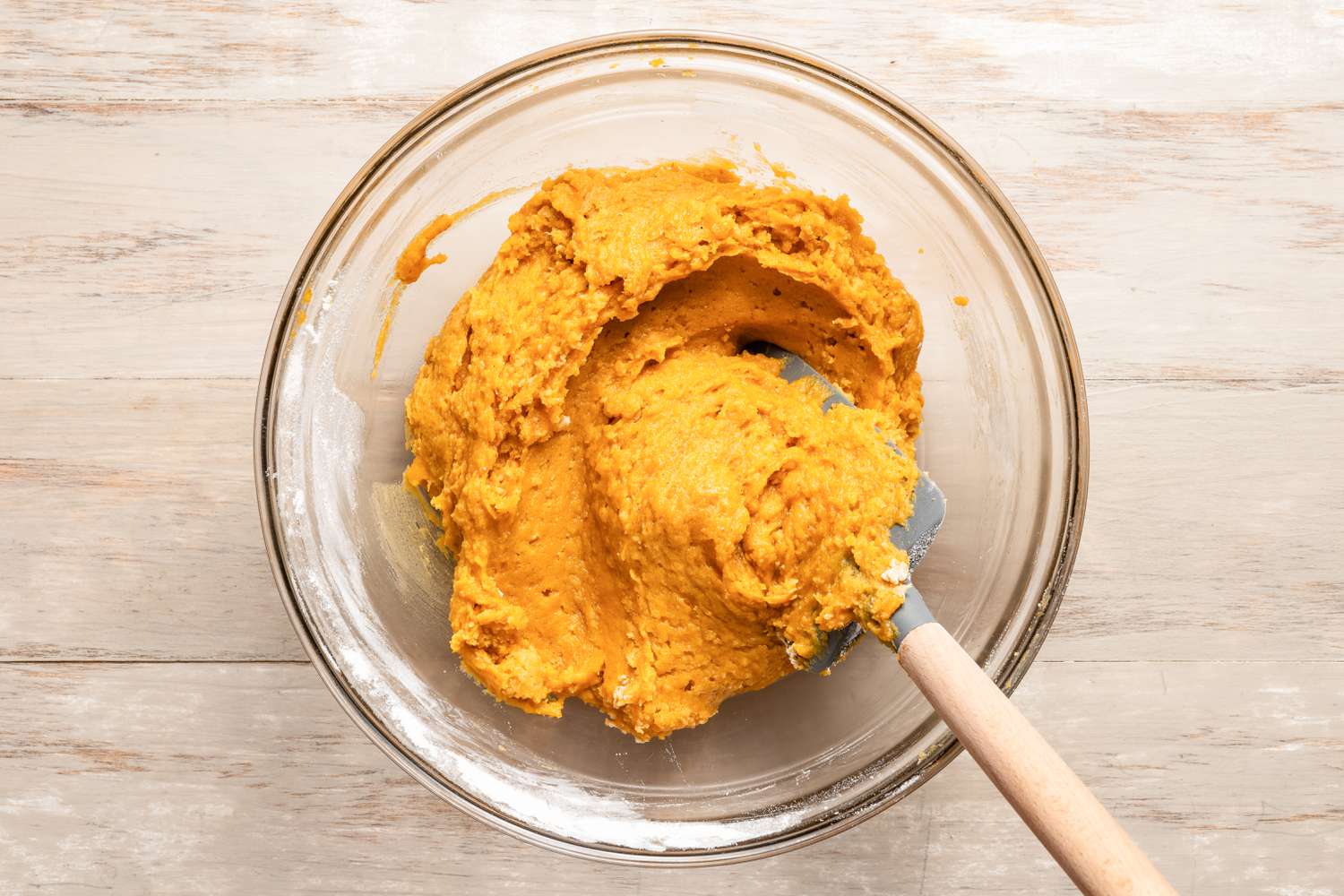 Pumpkin spice snickerdoodle cookie dough in a bowl with a rubber spatula