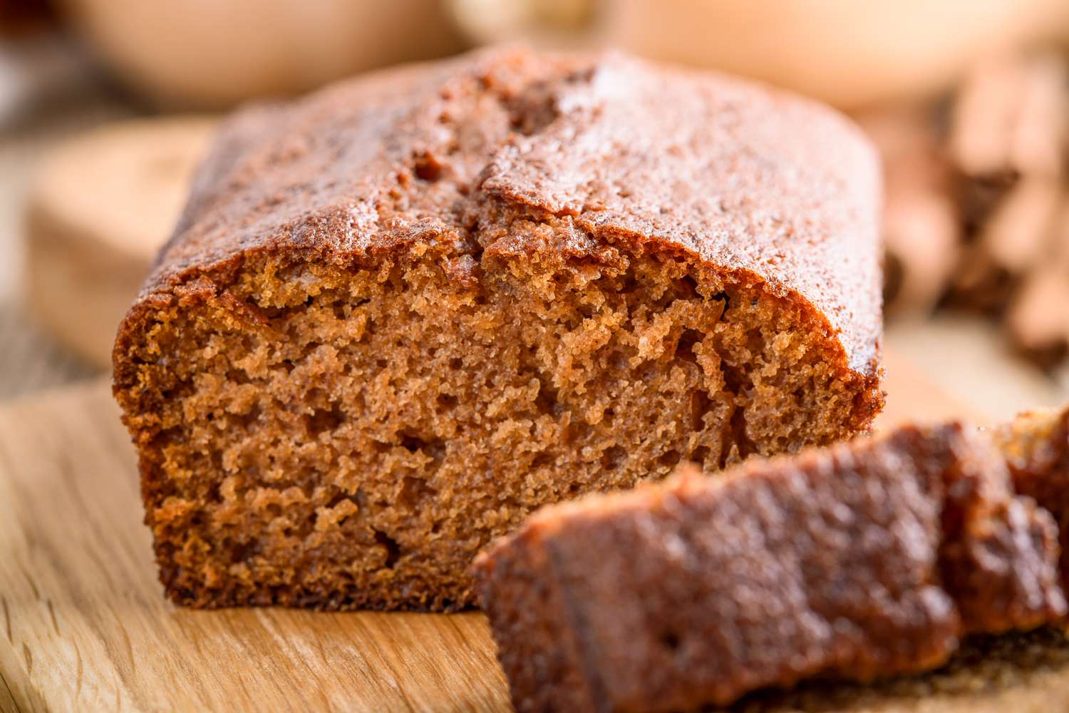 A sliced loaf of spice cake on a wooden surface