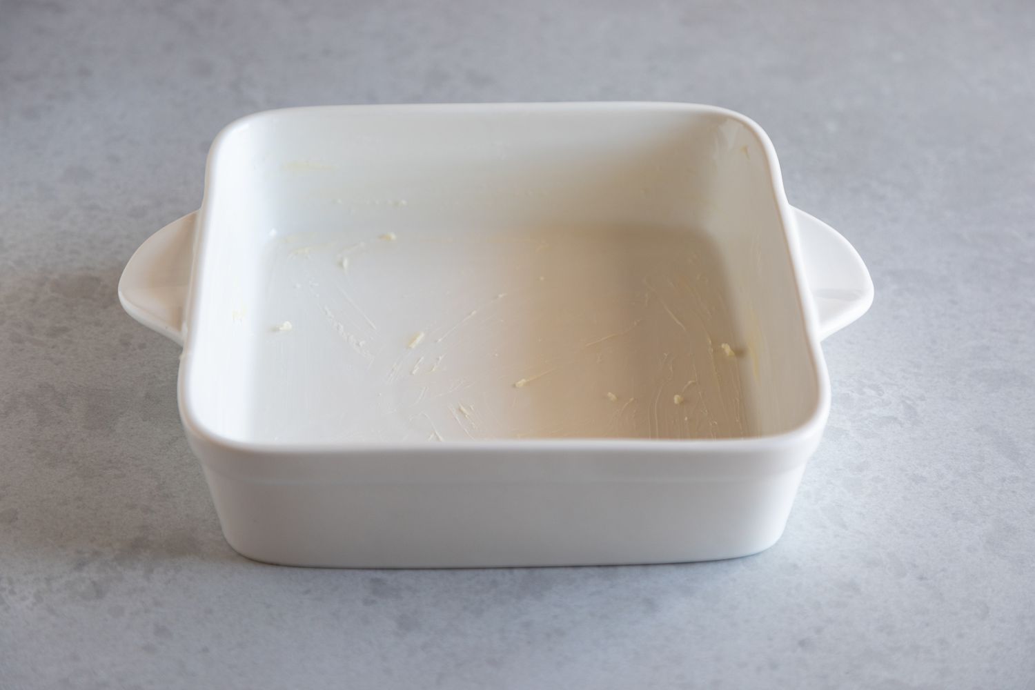 A square white ceramic baking dish to make Overhead view of a baking pan with Baked Berry Oatmeal.