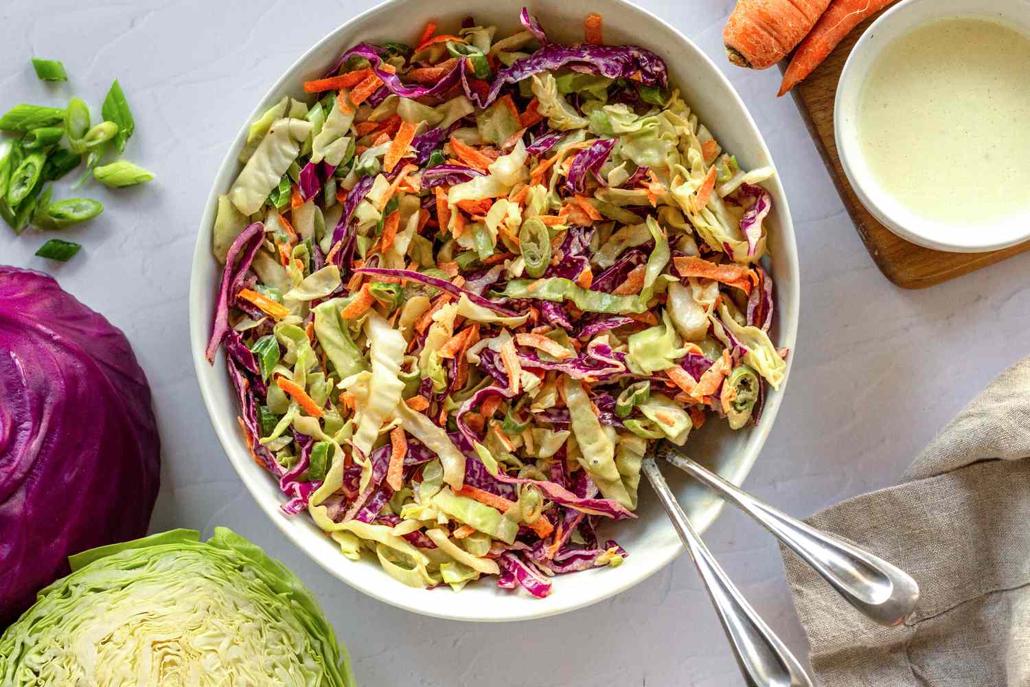 Mixed Classic Coleslaw in a serving bowl with the ingredients around the bowl.