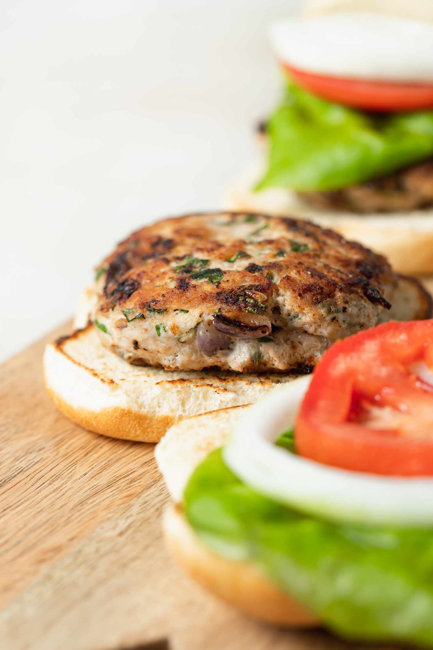Side view close up of partially assembled turkey burgers.