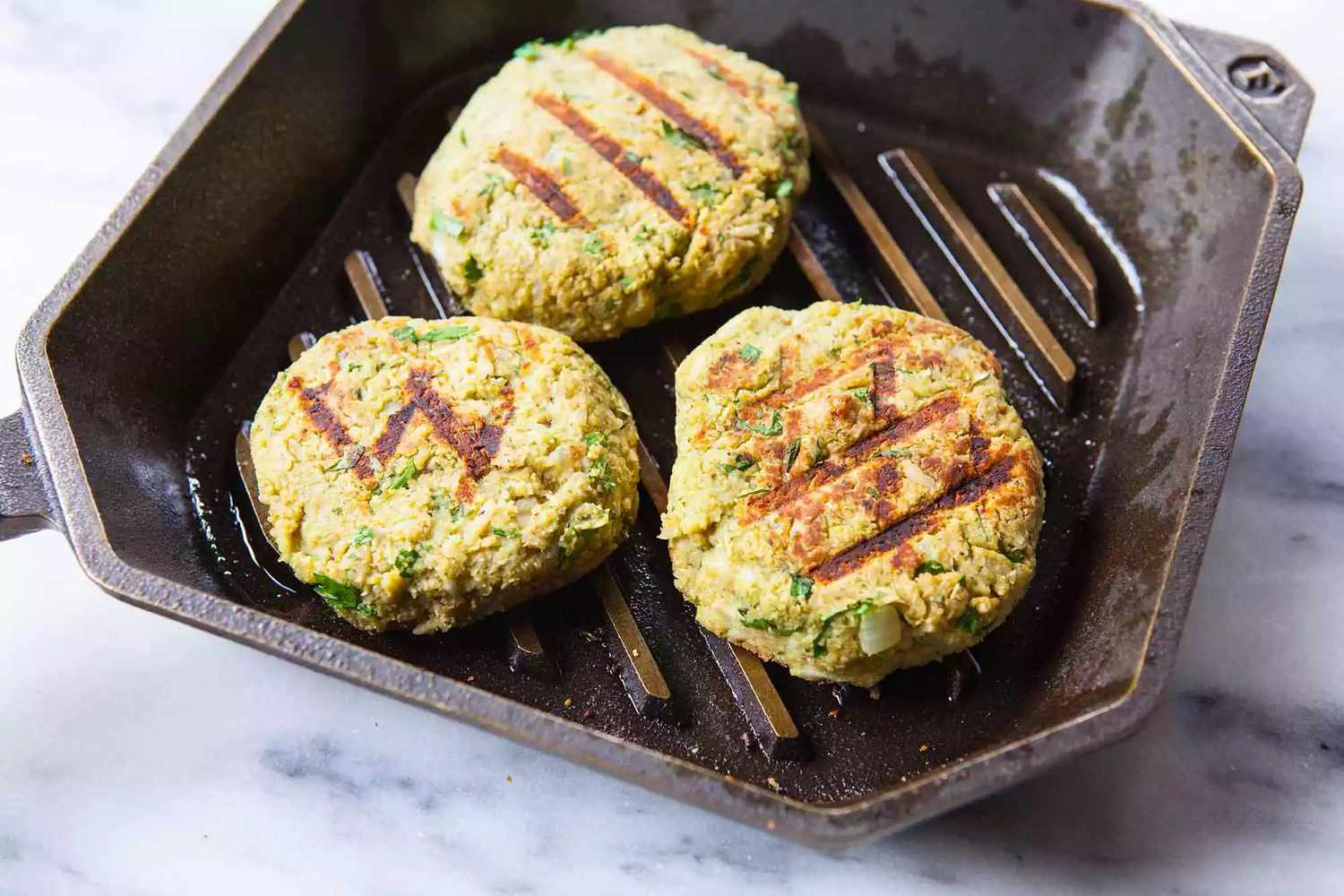 Three patties in a grill pan to show tips to make a great veggie burger.