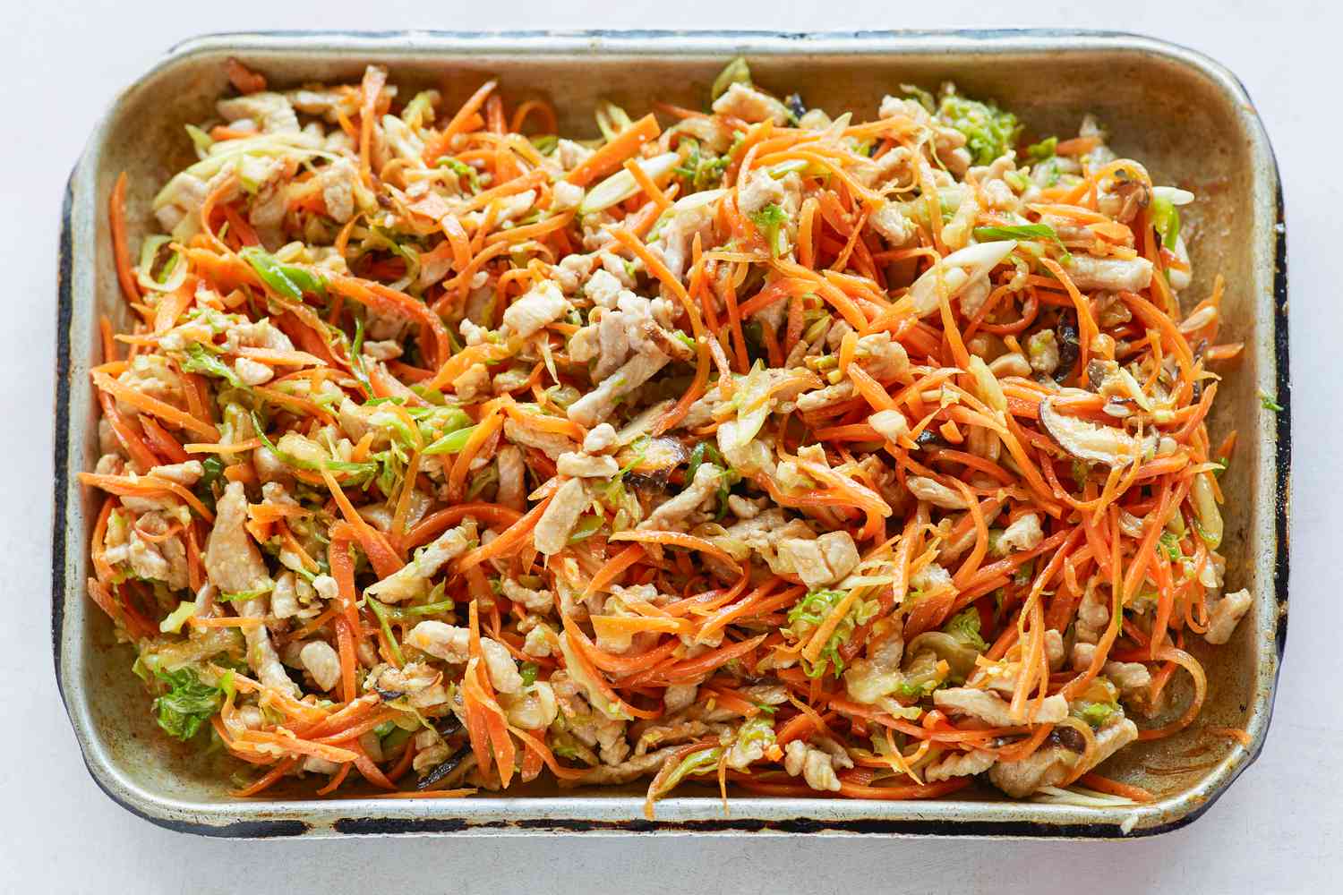 Sheet pans with vegetables to make the filling for spring rolls.