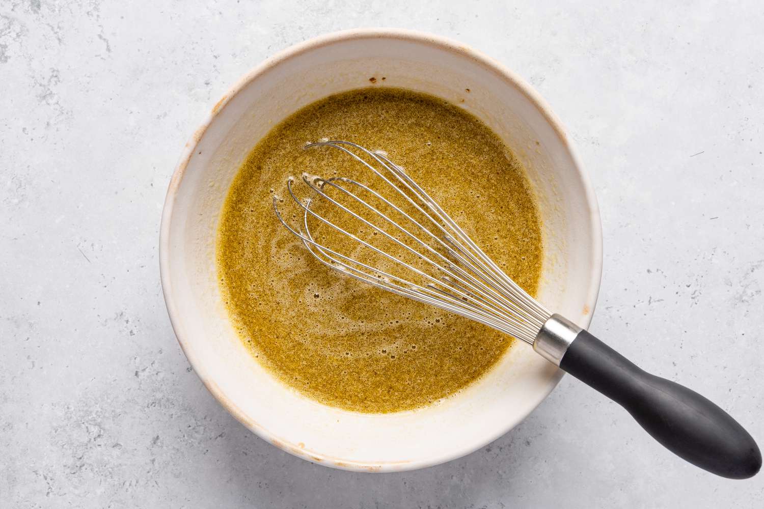 A whisk in a bowl with the wet ingredients for the Chocolate stout loaf cake recipe batter