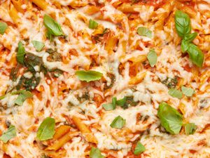 Close-up: one pan baked penne alla vodka topped with pieces of basil
