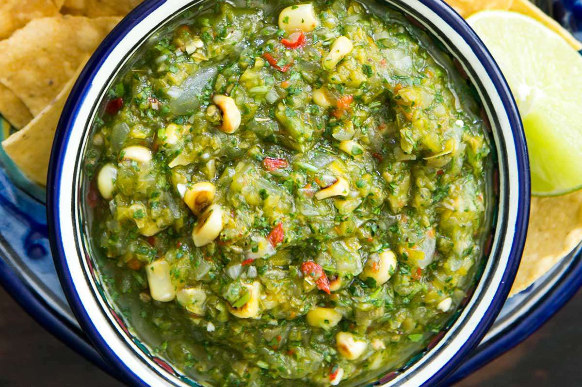 a bowl of cactus and corn salsa with tortilla chips