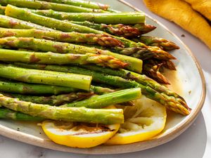 Grilled asparagus on a plate with lemon slices