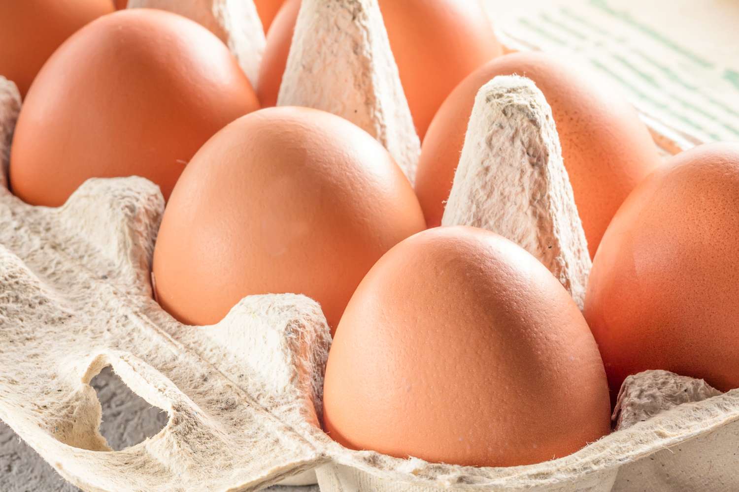 A closeup view of eggs in a cardboard carton