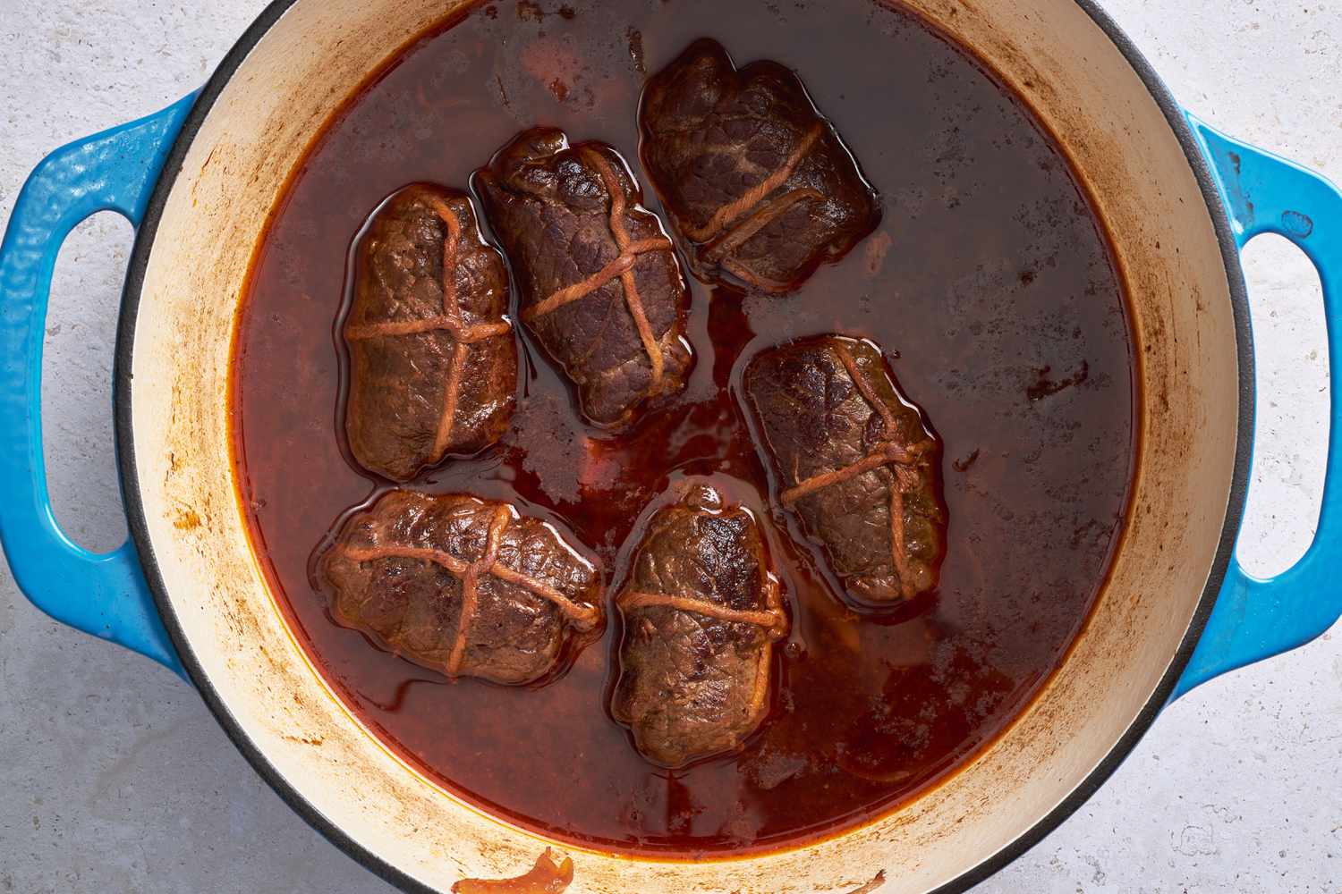 Overhead view: rouladen brased in the sauce in the Dutch oven