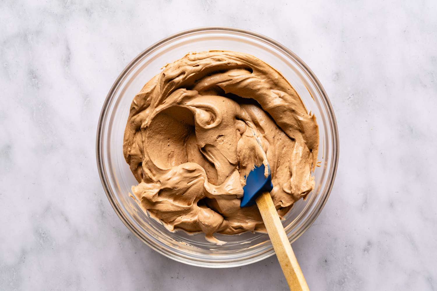 Bowl of chocolate cream topping for Italian love cake recipe mixed with a spatula