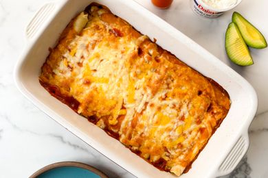 Taquito enchilada casserole in a white baking dish