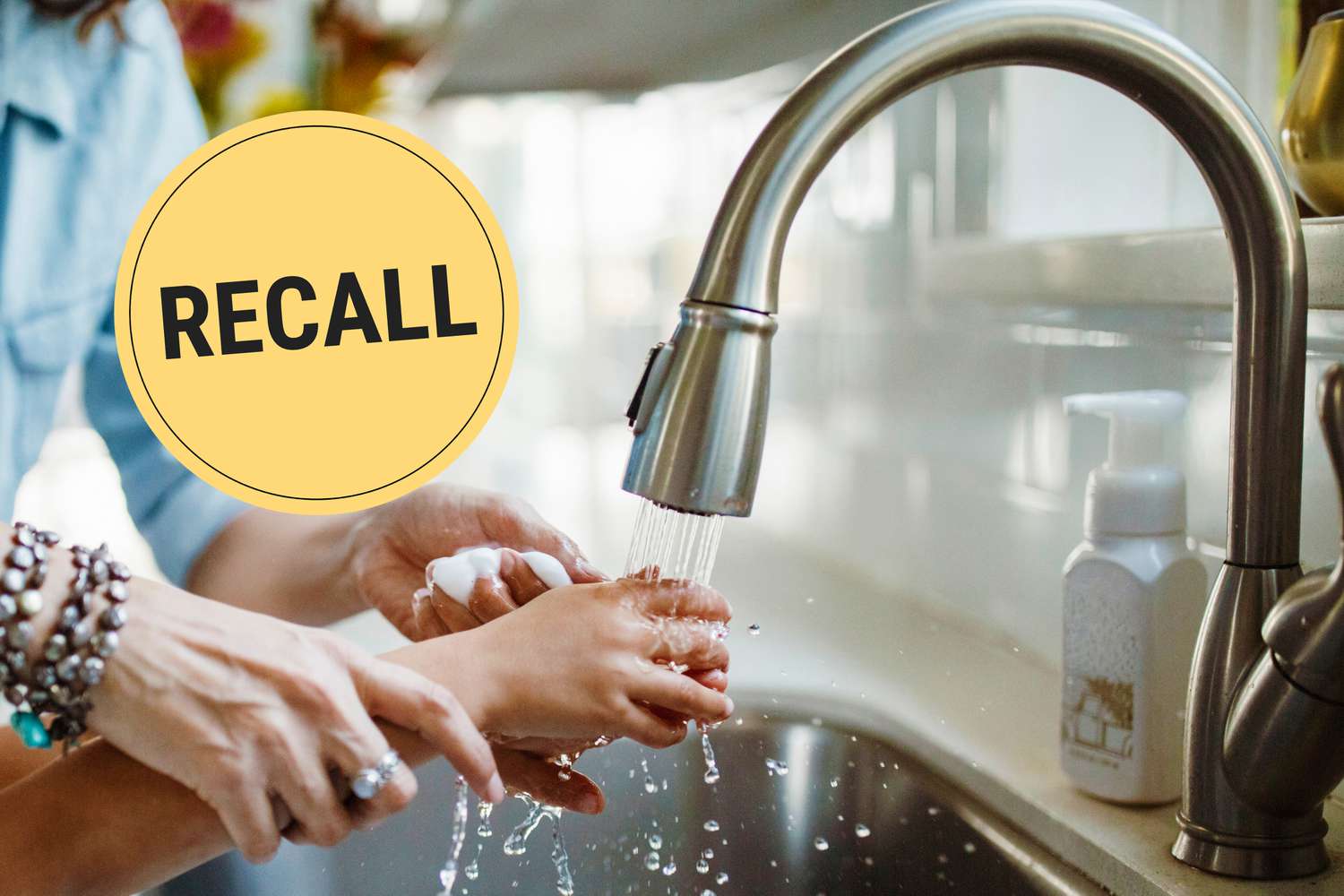 Hands being washed under a faucet with a 'Recall' label displayed