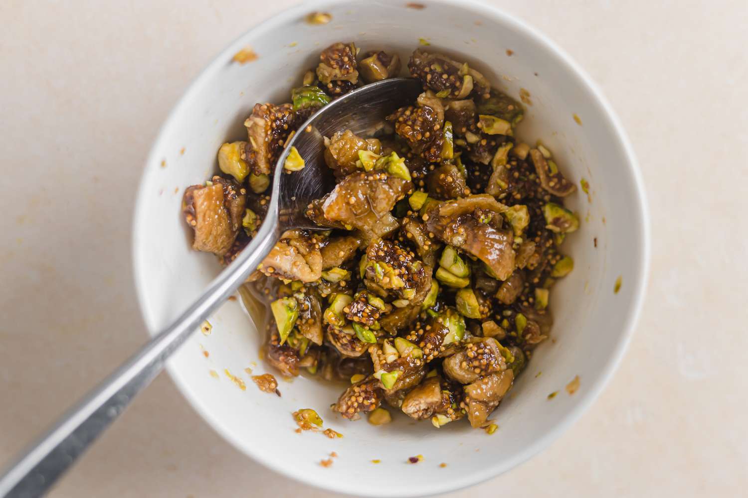 Stirring ingredients together of whipped feta with figs, nuts, and honey.