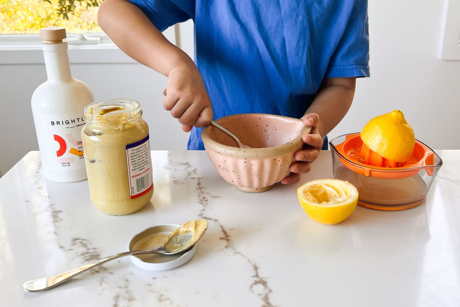 kid whisking salad dressing in the kitchen