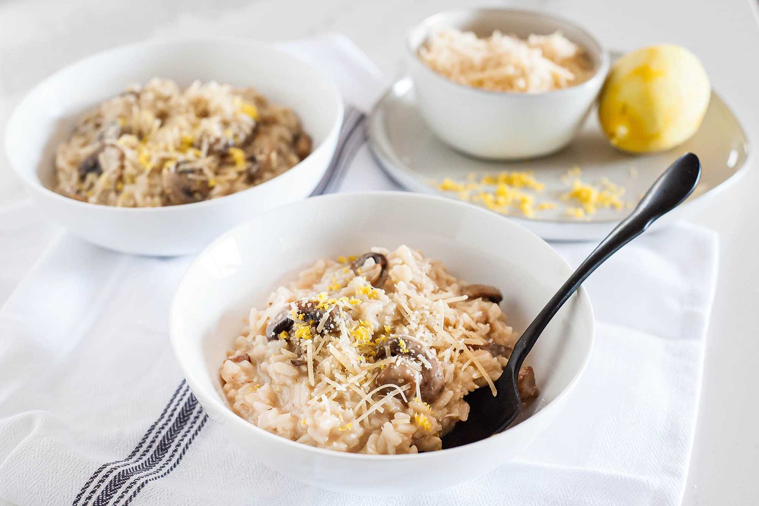 Risotto with Mushrooms - white bowls filed creamy mushroom risotto