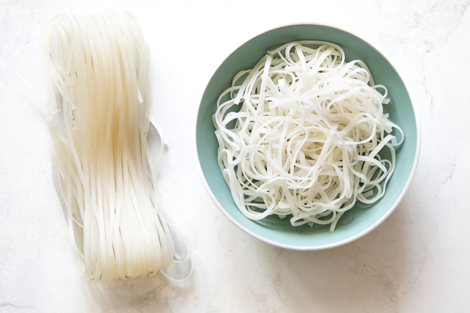 Dried Rice Stick Noodles on the Left and Cooked Rice Stick Noodles in a Bowl on the Right