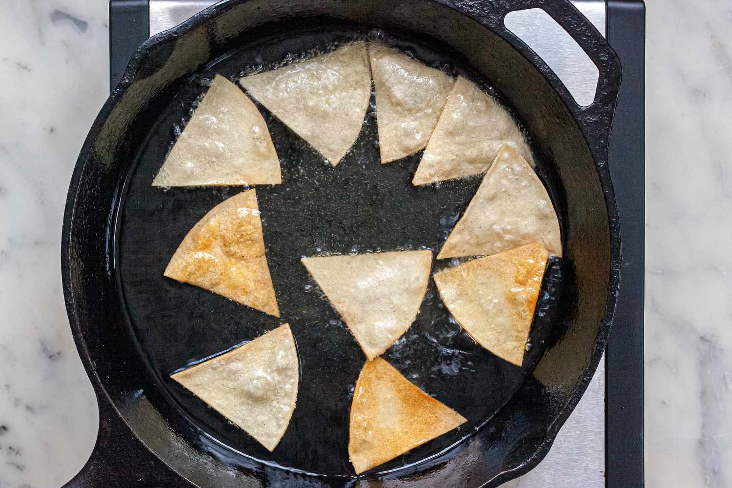 Frying tortilla wedges in a cast iron skillet