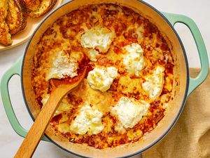 Braised cabbage lasagna in a pot with a wooden spoon