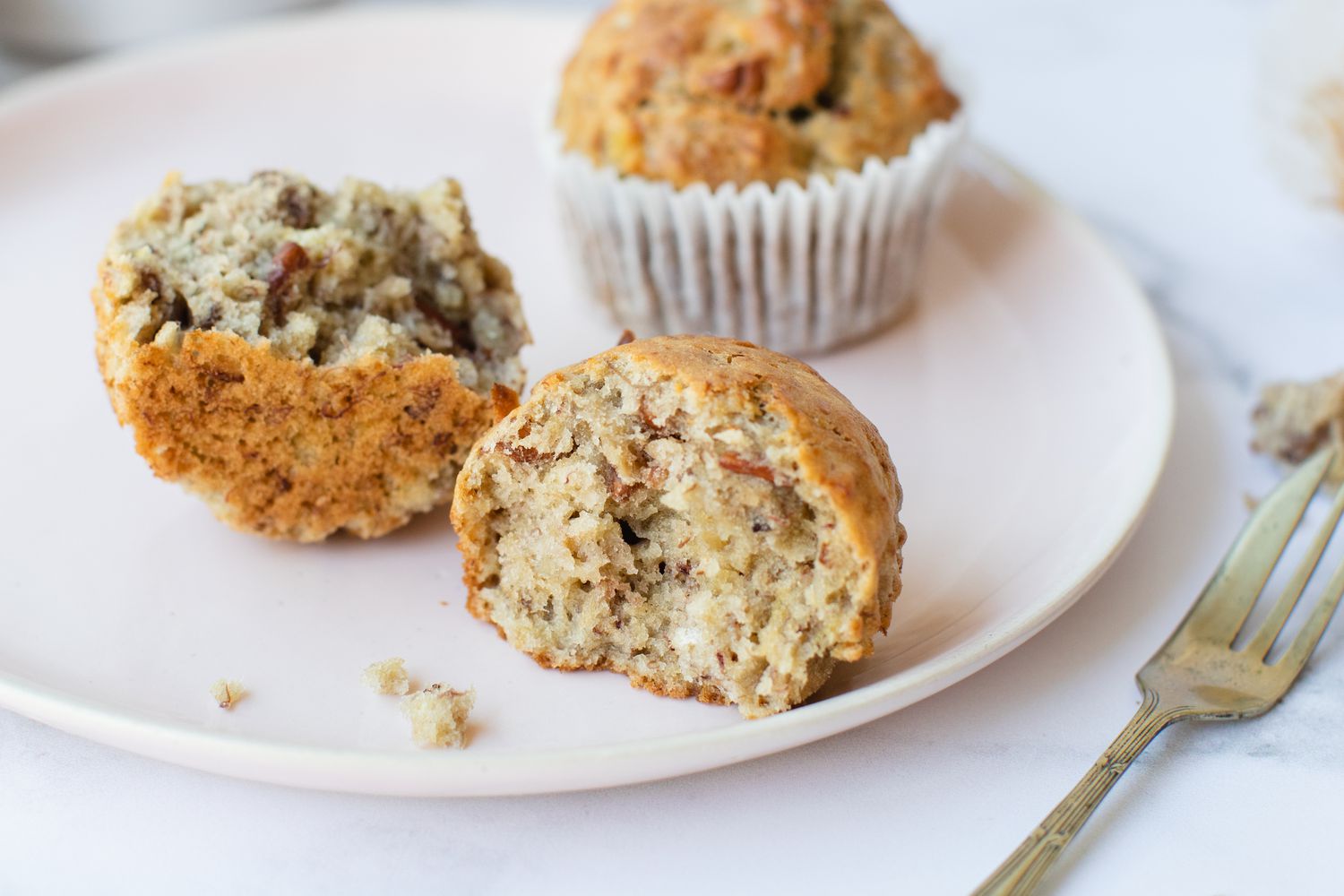A plate of Banana Nut Muffins split open and ready to eat