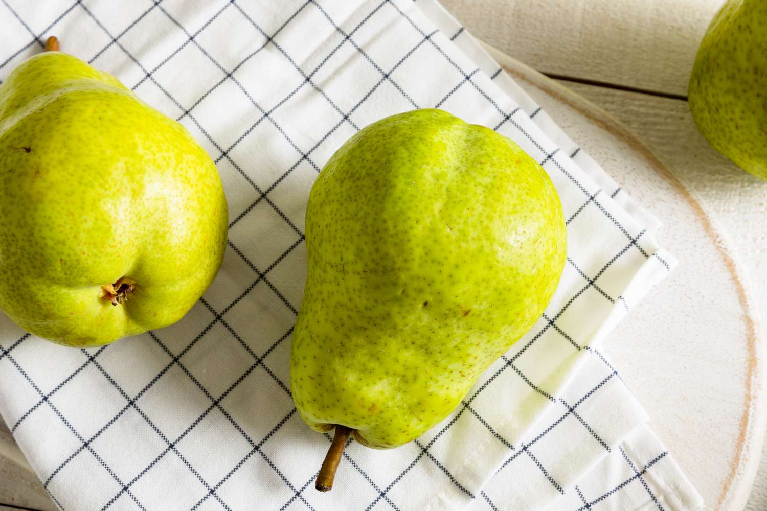 Three Bartlett pears on a checkered cloth