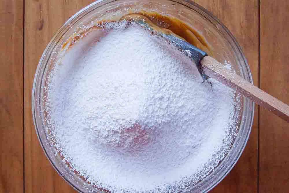 Powdered sugar sifted over top of the peanut butter mixture for chocolate ball candy.