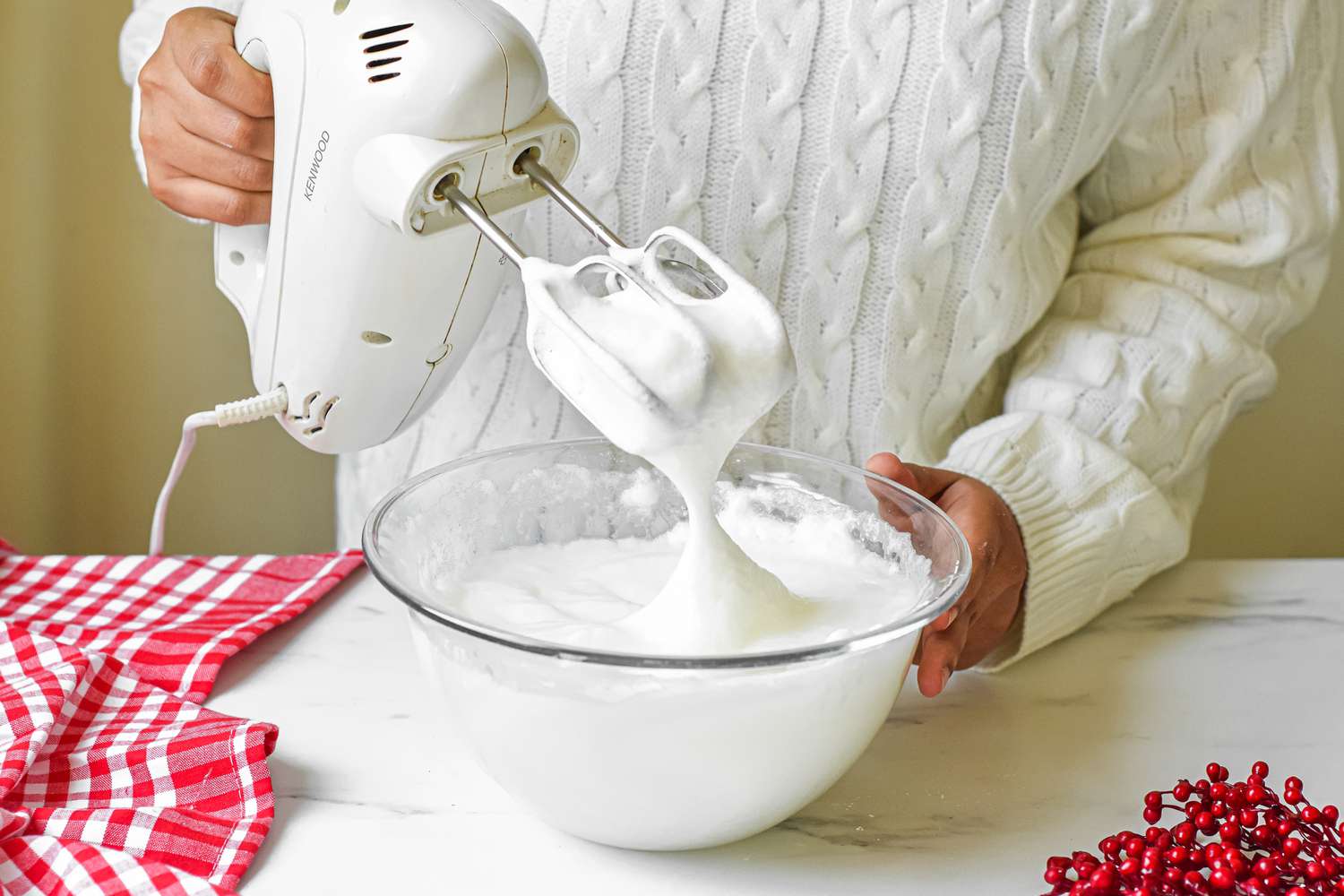 Egg whites being beaten in a glass bowl with a hand mixer