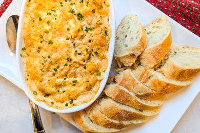 New Year’s Eve Hot Crab Dip in a dish with slices of bread