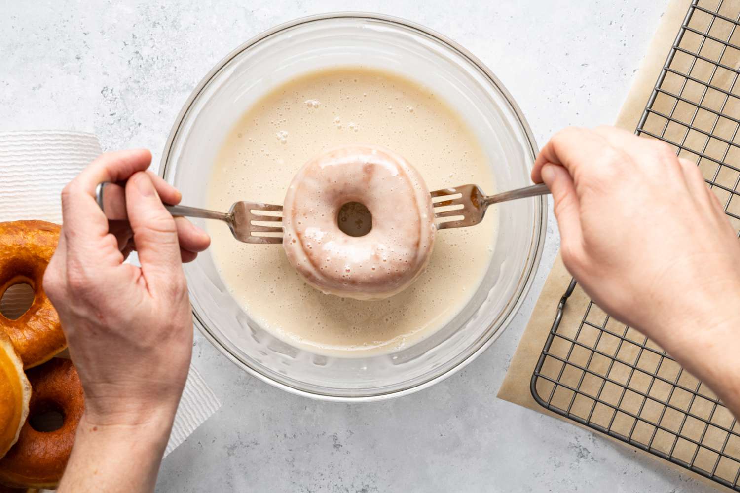 Glazing Process: Donut Flipped to Glaze the Other Side and Raised Using Two Forks