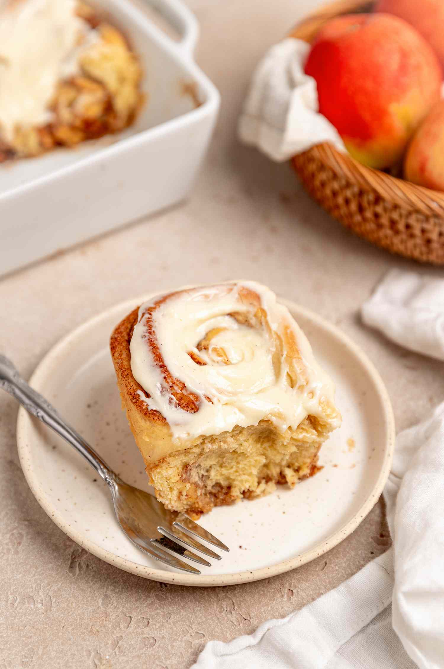 Apple Cinnamon Roll on a Small Plate with More in the Casserole Dish in the Background