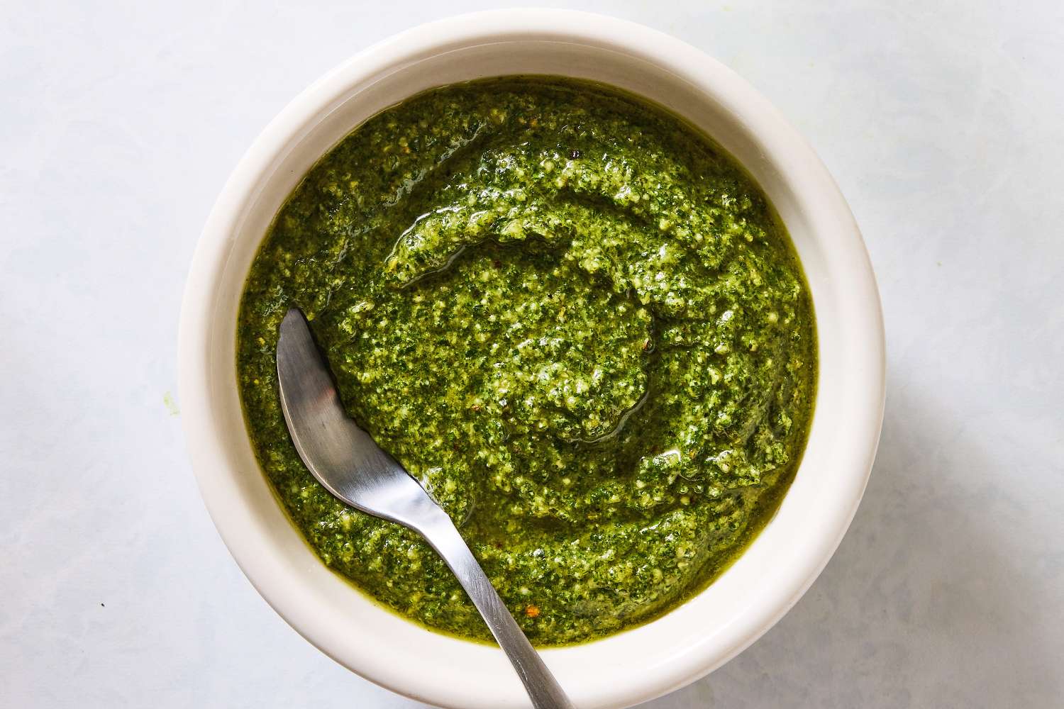 Bowl of pesto sauce with a spoon