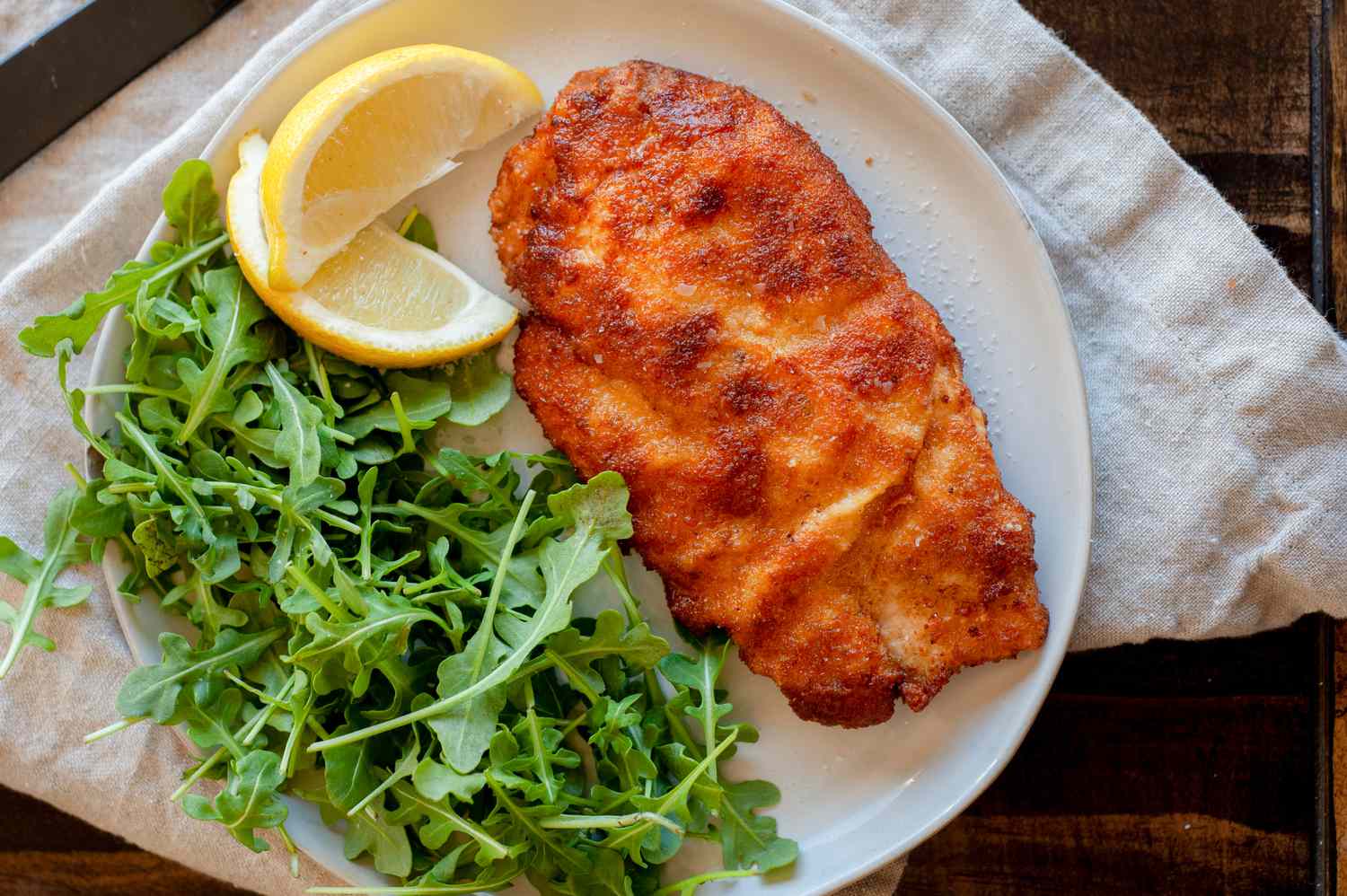 chicken schnitzel with arugula and lemon wedges
