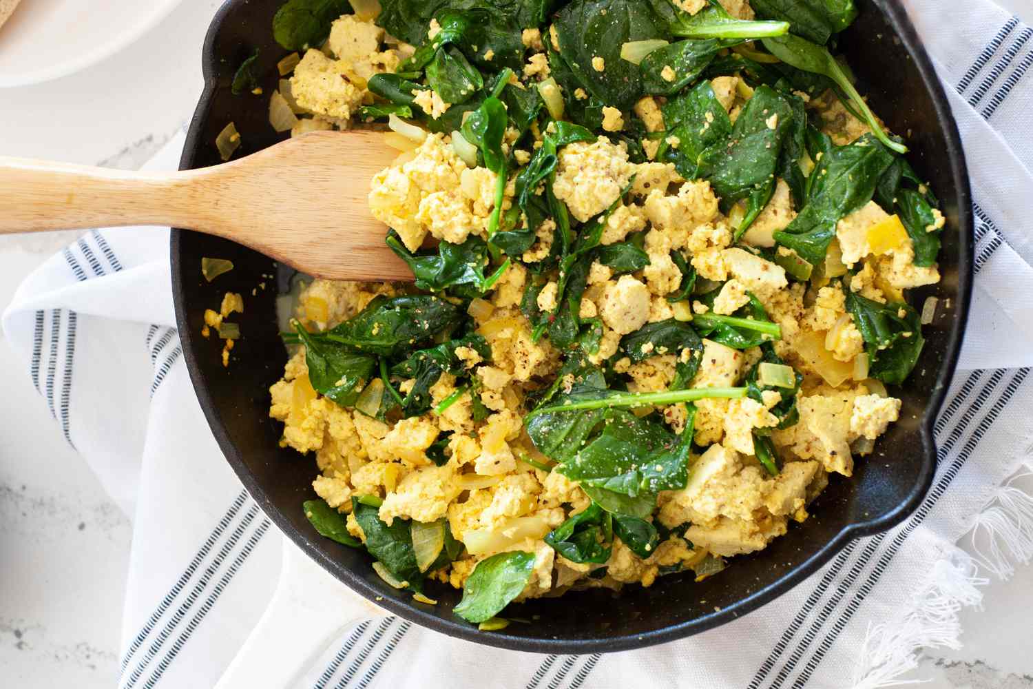 Vegan spinach and tofu scramble in skillet.