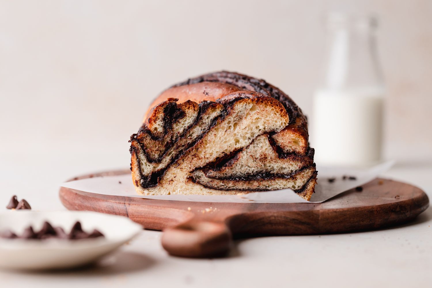 Side view of chocolate loaf bread on a cutting board and with the swirls showing on the cut side.