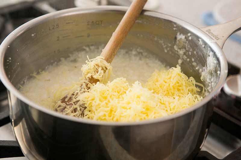 adding cheese to shrimp and grits recipe