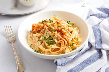 Cajun shrimp alfredo in a white bowl with a fork on the side