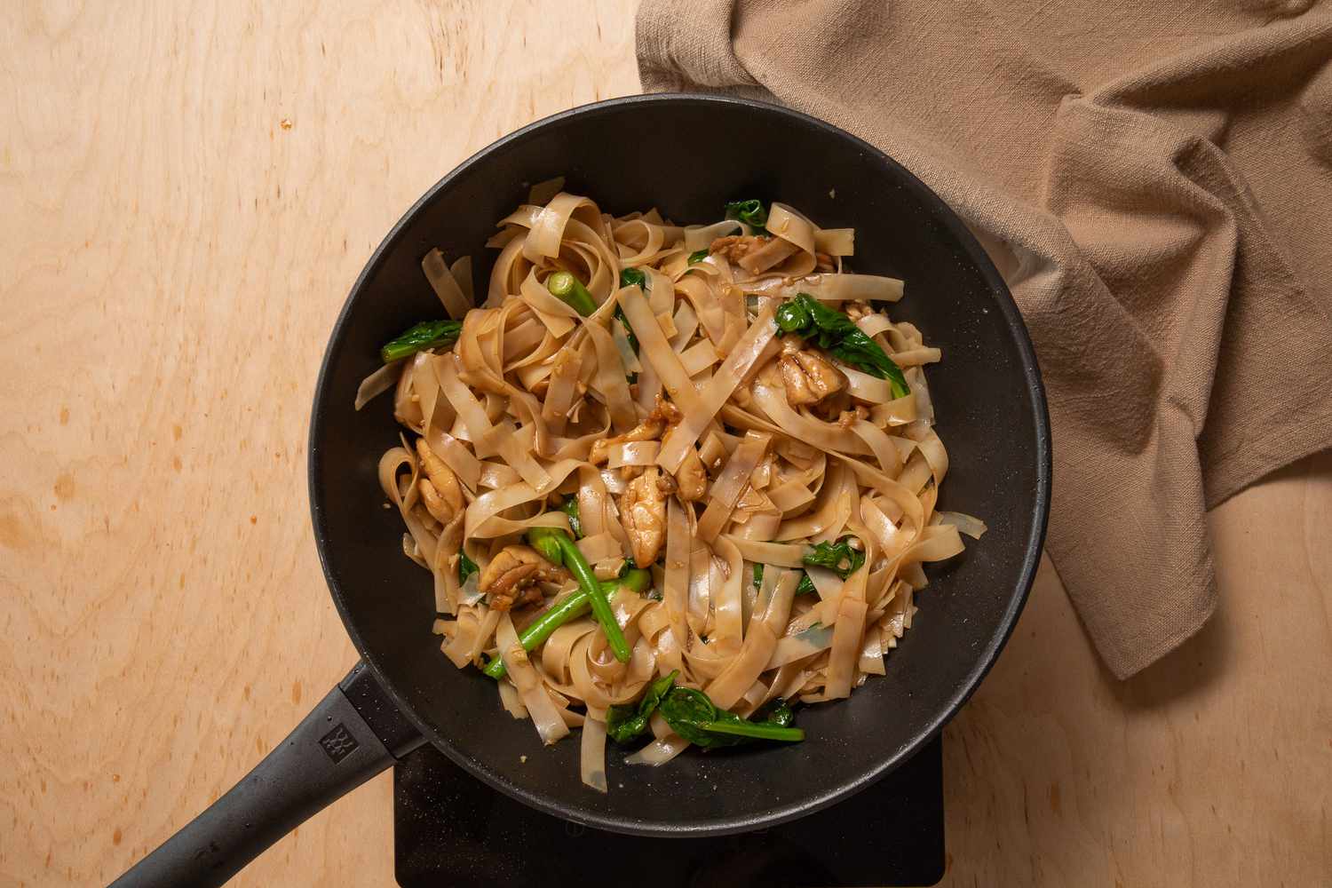 sauce added to the ingredients in the wok for pad see ew recipe