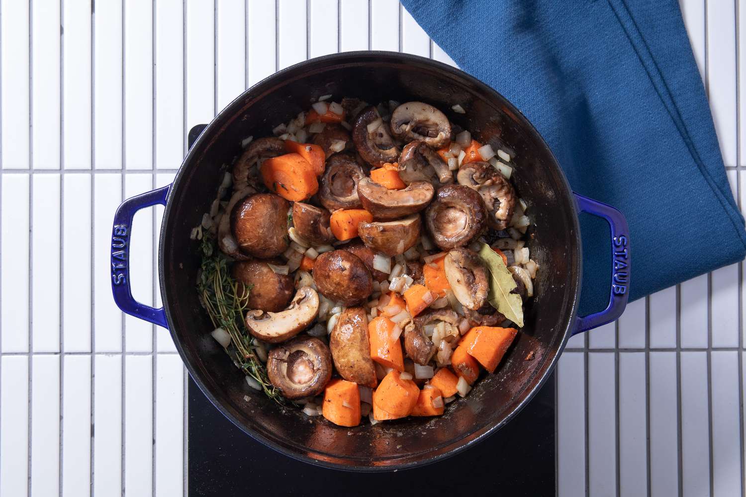 aromatics and carrots added to dutch oven for chicken fricassee recipe