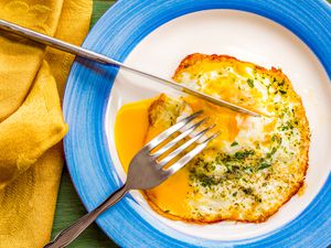 fried runny egg over easy with salt, pepper, and parsley
