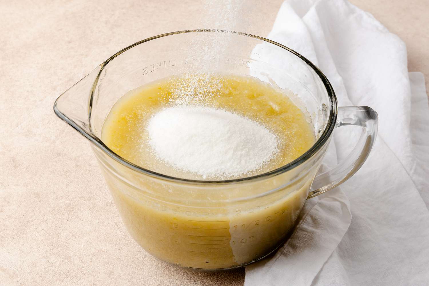 Sugar Added to Measuring Cup with Sieved Apples for Apple Butter